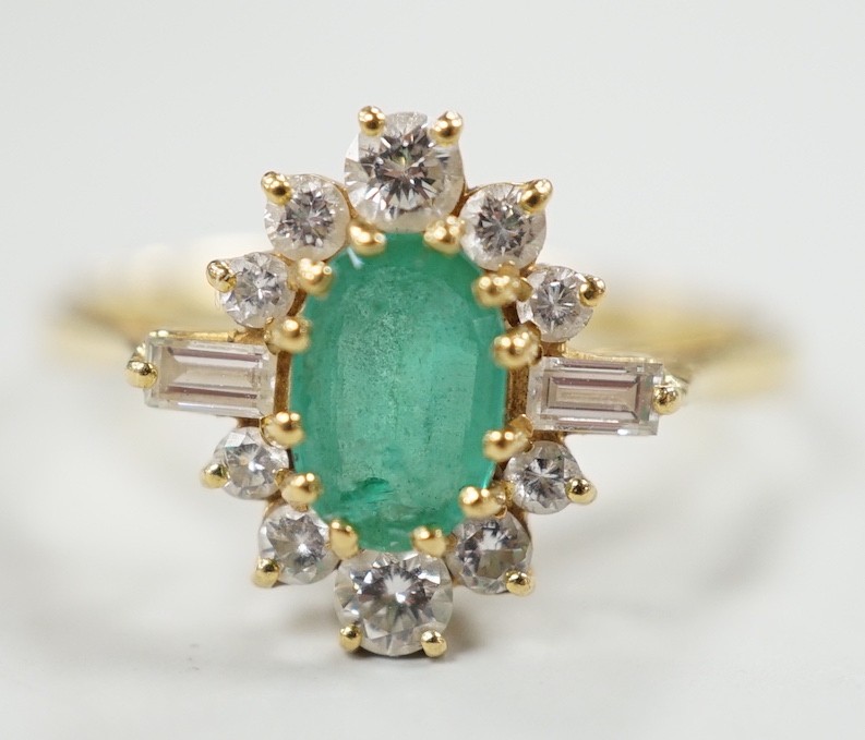 A modern 18ct gold, single stone oval cut emerald and round and baguette cut diamond cluster set ring, size P/Q, size 3 grams.